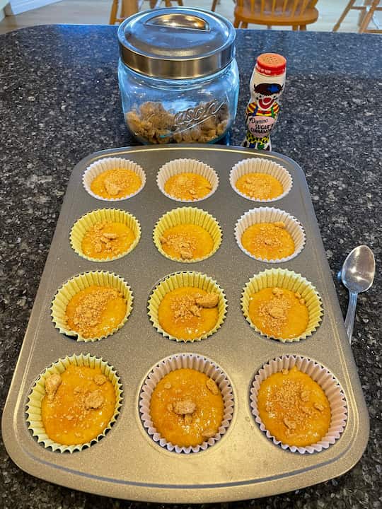 I placed paper muffin cups into my muffin pan and I used a cookie scoop to place the batter in the muffin cups.  I decided to sprinkle on a little cinnamon and sugar onto the top.  I also had a little bit of brown sugar to use up so I placed a little bit of that on top of the muffins as well.  