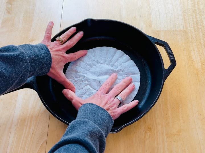 placing coffee filter in a cast iron pan