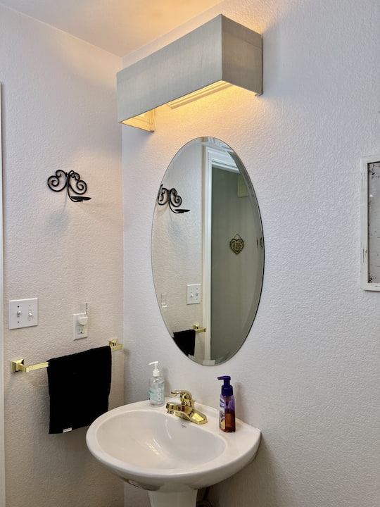 Have you ever wanted to makeover a bathroom vanity light?  We had a dated light in our bathroom that needed an update.  This is my DIY and you could easily do this in a rental home.