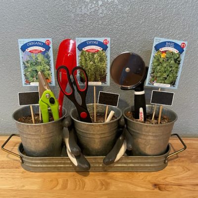 I added the chalk so they would have it for the garden markers. I added pruners to help care and shape the plants. I added items that would be helpful in the kitchen to use the herbs like the scissors, pizza cutter, and rubber scraper. I placed them into the dirt representing flowers or the plant.