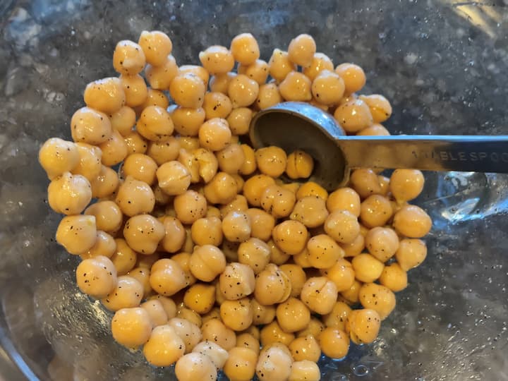 Place the chickpeas in a bowl.  Mix in 1 tablespoon olive oil, 1/4 teaspoon salt, and 1/4 teaspoon pepper.