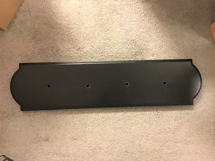We purchased a pine board from Hobby Lobby. We measured and drilled 4 holes in the pine board. We lightly sanded the board to make sure it was smooth and wiped it off. We painted one couple of coats of Varathane 8 oz. Ebony Premium Fast Dry Interior Wood Stain.