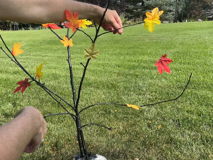 I hot glued the other end of the fishing line to one of the branches.  This gives the illusion of leaves falling from the tree.