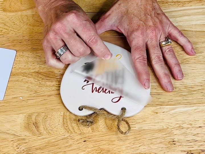Follow the instructions on the rub-on transfer package to apply the design to the ceramic heart.Use a credit card or hard surface to ensure a smooth application.
