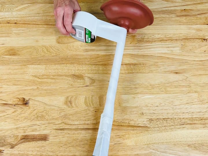 Reinforce the branches by wrapping small pieces of duct tape around them.

Continue wrapping duct tape all the way down the plunger.