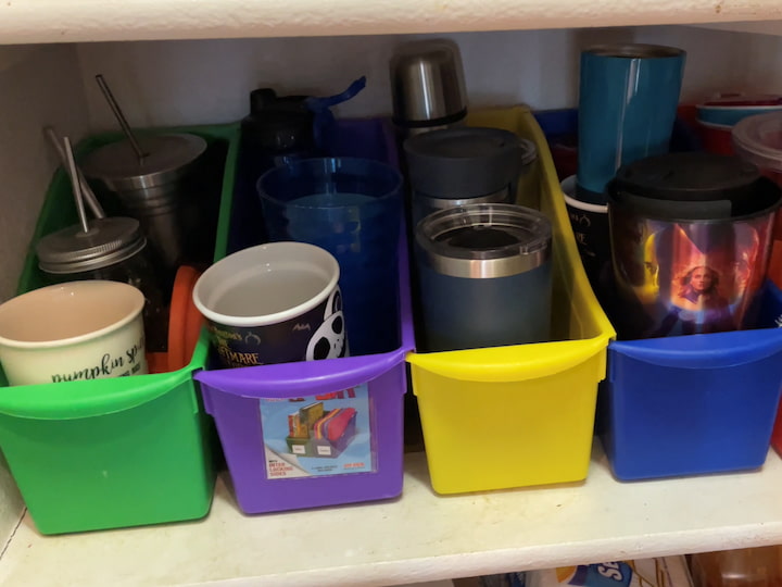 I was so tired of all of our travel cups falling over like bowling balls when you would reach in to grab one.  I bought book and magazine storage boxes that connect together, and each color represents a family member.  We put their travel cups in those and it has really helped our pantry.