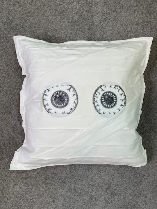 I created an inexpensive cute mummy on one side and a snowman on the other side of a pillow cover, and it packs away easily too!