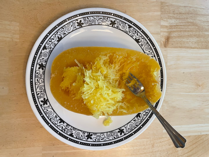 Scoop out the spaghetti squash in solid chunks, or by scrapping with a fork to create a more noodle-like texture.