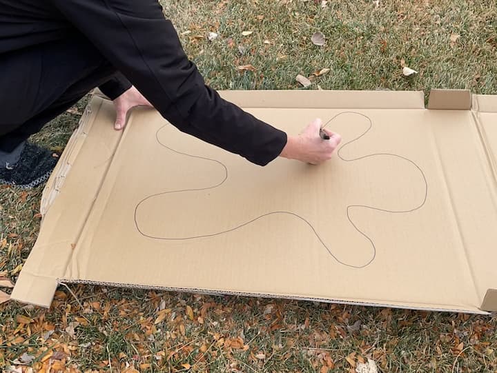 1.  Draw a giant gingerbread man onto the cardboard