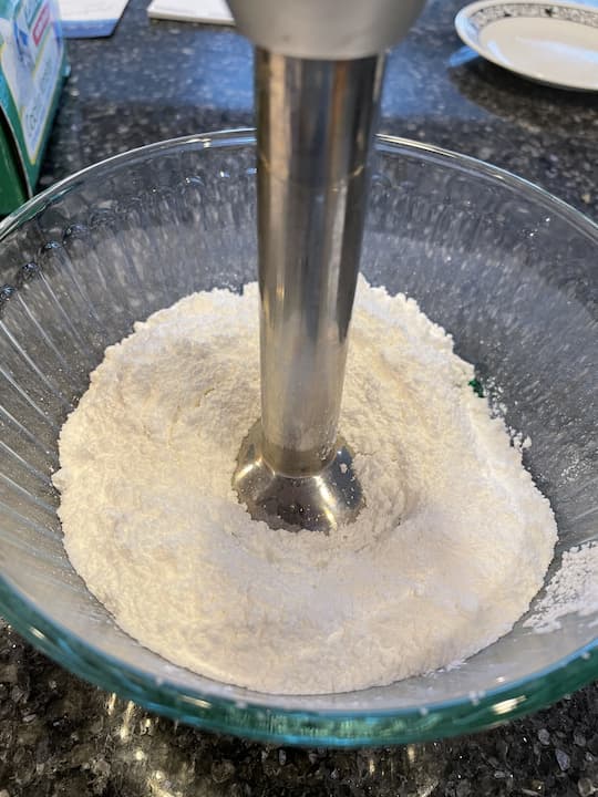Add powdered sugar into the bowl and use your Immersion Hand Blender or stir with a spoon.