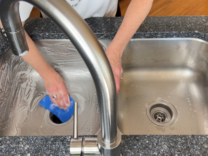 I rinse out my scour pad, add a little Castile soap to it, and then scrub the sink again.  This disinfects the sink.  After the sink has been scrubbed, I rinse the whole thing clean.  Don't forget to clean your faucet too.