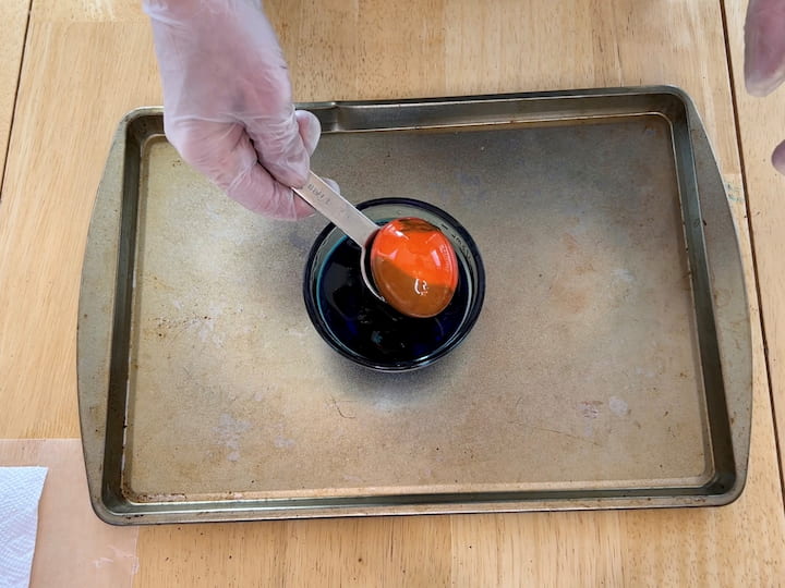 Dip the egg into the second dye with the oil, dunk a couple of times