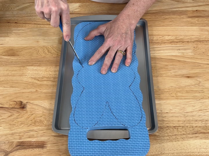 I placed my foam garden pad onto a cookie sheet to protect my tabletop.  I used a serrated knife that I purchased for crafting to cut out the bunny shape.  You could also use scissors, heat knives, or a razor blade if you'd rather.