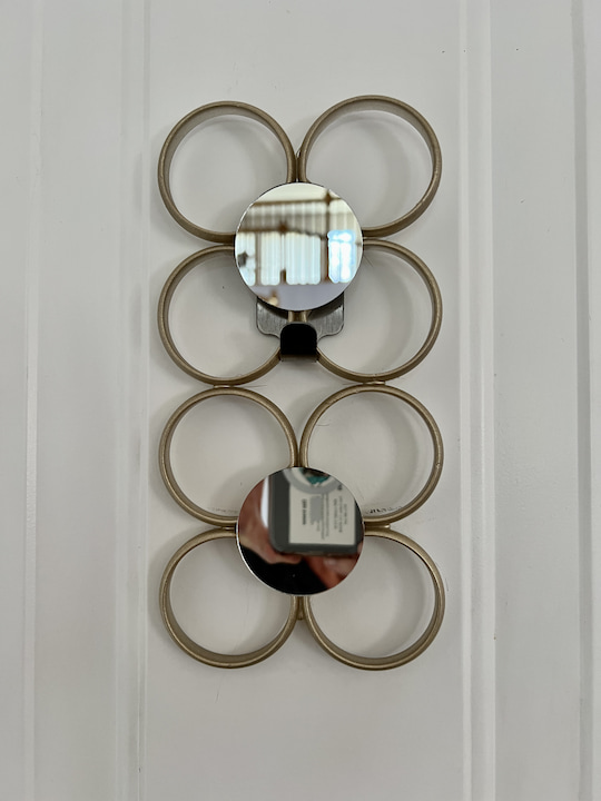 Here is another geometric design I made by gluing 8 shower curtain rings together, painting them gold, and then gluing on the mirrors. I put this in the center of a door to give the door an accent.