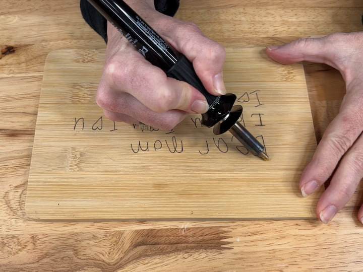 Pick the tip you want to use on your wood-burning tool, and turn the temperature from medium-high to high.  Once it's heated slowly trace the image or letters with the wood-burning tool.