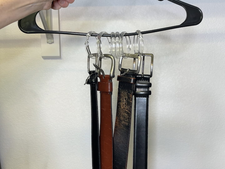 Hook belts onto the shower curtain rings for accessory storage.