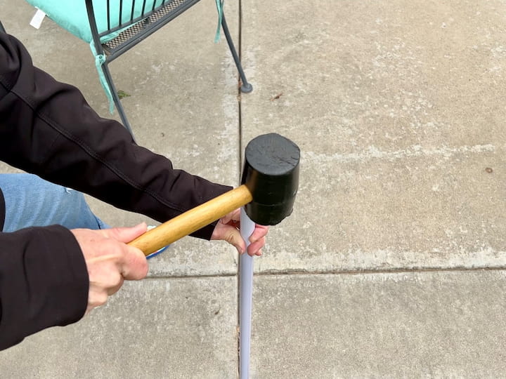 I used a rubber mallet and pounded the broom handle into the ground near my patio.