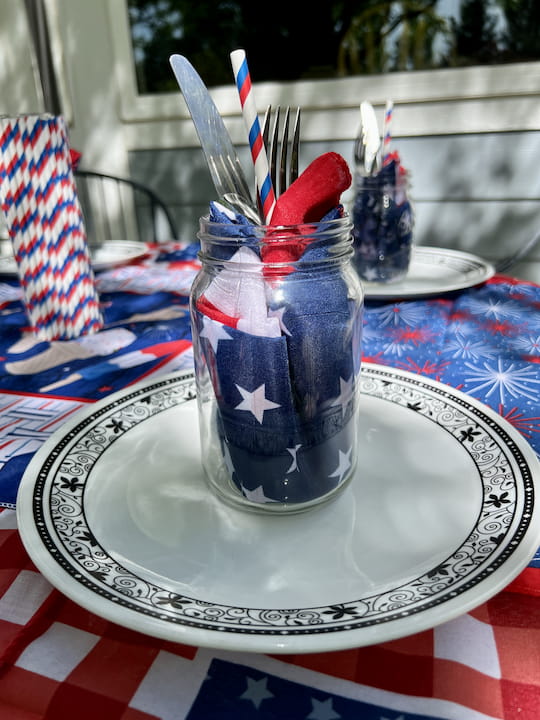I placed a bandana inside a mason jar and then in the center of that added silverware and a straw.  The bandana will become a reusable napkin, and the mason jar will become a drinking glass.  What a great way to be eco-friendly!