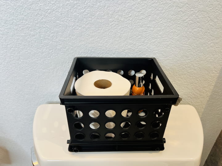 I like to place items in small crates for easy cleaning.  Here you'll see I placed the back up toilet paper and room spray in a little crate.  This way I can pick the whole thing up easily and clean under it.  I like to do this in my showers as well with all of the shampoo, conditioner, soap, etc in one basket.  Pick it up, wipe under it, and keep going.  Easy cleaning.