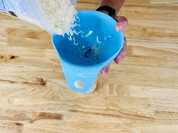 I placed a funnel on the top of the bottle and poured my rice inside.  This is especially helpful if you have a bag of a product.  Bags take up so much valuable space and this creates vertical storage.