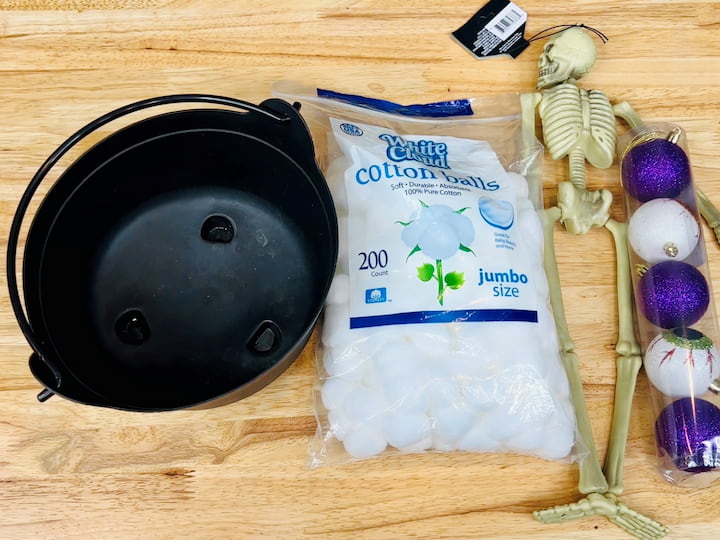 For this first simple project, you're going to need some small bulbs, a skeleton, cotton balls, and a cauldron. All of these items can be found at your local dollar tree or craft store.