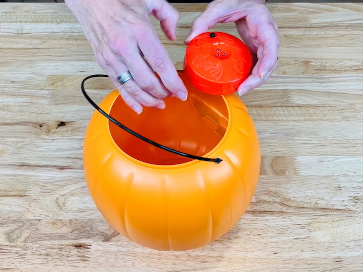 1. Place an LED light into a pumpkin pail.