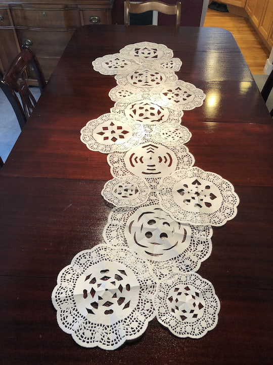 I used different sizes for my table runner. I layered the doilies into the shape that I wanted, and I hot glued the edges together.