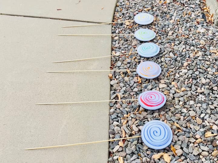 I used paint pens to make a swirl shape to create lollipop ornaments and repeated this to make several for my yard.