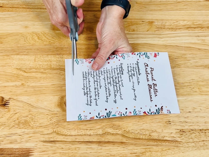 For this next cutting board craft, I'm using a red cutting board. Start by removing the label. I've printed out a recipe and trimmed it to fit the cutting board. This is the perfect craft to preserve a family heirloom recipe. 