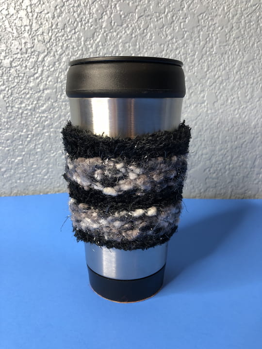 I then took the cup and slid the cuff of the sock onto the mug. I slid it about halfway up until it looked like this. I created a really cute coffee cozy for my travel mug. 