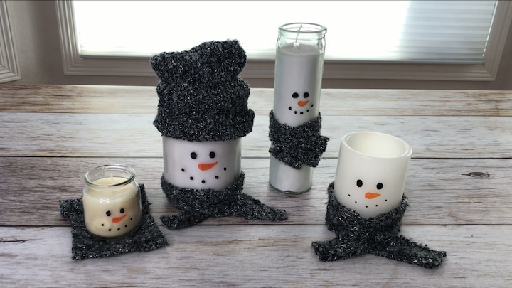 I made several candles as snowmen. I painted faces on all of them. They ranged from left to right a small jar candle, a large jar candle, a tall skinny candle, and an LED candle. I had some fabric so I cut out little pieces to add scarves to the candles and made a hat for the large candle, as well as a little coaster for the small candle.