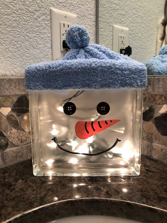 I added a dollar store hat onto the top of the block, and I used a rubberband to create a little ball on top.  I love this as a nightlight in our bathroom.