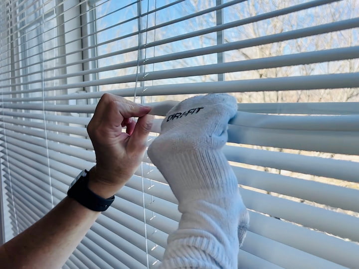 If you don't have a vacuum cleaner that can use this easily take an Old Sock. Maybe one that you don't have a match for anymore and you can use this to Simply wipe down the blinds as well the other thing it can do is get right in between each of the blinds for a little extra cleaning. You can also make them damp so that it cleans them even better and the great thing about something like this is you can wash and reuse it again and again.
