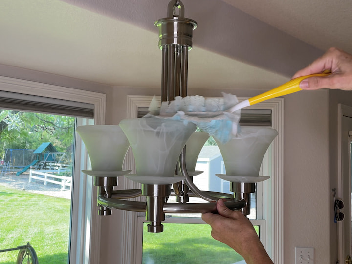 Let's talk about light fixtures.  I use a duster to get the entire fixture all the way around cleaning on a weekly basis.  Another option is to rely on your vacuum cleaner and its attachments so you can get in here and dust all the creases and crevices with your attachments.  Get your light bulbs and all of those areas and you can keep up with this on a weekly basis too which is great about this is it's an all-in-one thing so you're vacuuming and dusting with one thing. 