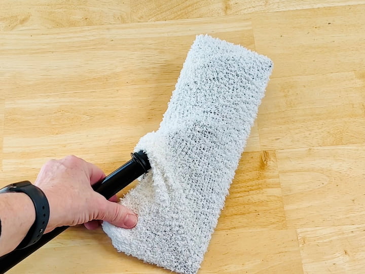 I'm placing one of the socks onto this swifter-style mop. The great thing about this is that it's very eco-friendly and reusable.