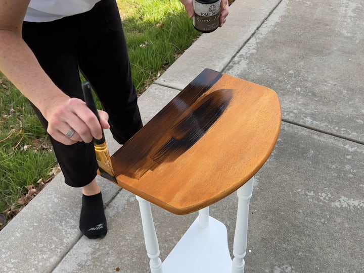 I thought the wood tint was a little more orange than I wanted it to be.   I brought the table inside to compare it to my other table and wanted it to be a little bit darker.  I used Folk Art Home Decor Wood Tint in the color walnut and painted over the entire top and sides of the table.   I work to get nice even brush strokes.  