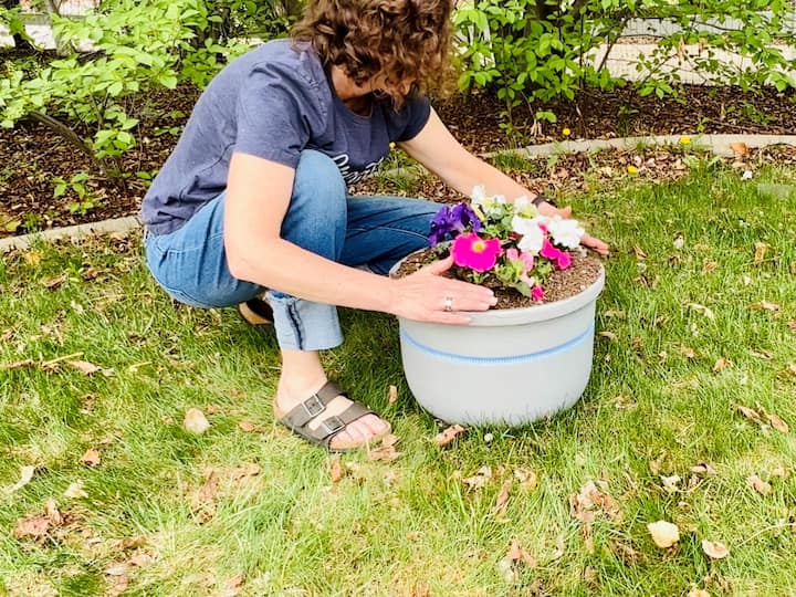 Now it's time to add your flowers to the planter. You can either place a flower pot into the other flower pot, or remove it from the pot and plant it directly into your planter. Either way, you'll save money on dirt and other fillers.