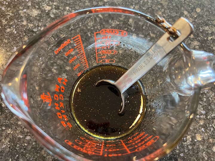 In a separate measuring cup, combine the ingredients for the dressing. Mix together 1/4 cup of olive oil, 2 tablespoons of balsamic vinegar, 1/4 teaspoon of pepper, 1 teaspoon of salt, and 1 tablespoon of sugar. Stir until well blended.