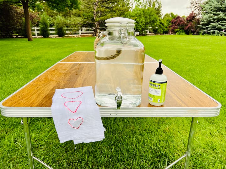 Maintaining proper hygiene is crucial, especially when serving food at a cookout. Create your own hand wash station by filling a beverage dispenser with water and placing it on the table. Keep soap and a towel nearby for convenience. Encourage your guests to wash their hands by demonstrating the process yourself—add soap, rub your hands, turn on the water, wash, and dry.