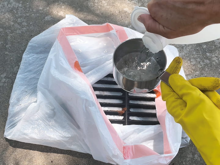 Vinegar and Ammonia Method: For the first grate, specifically the Weber grill grate, we placed it in a garbage bag and added three cups of vinegar and three cups of ammonia. After sealing the bag, we let it soak for 24 hours.