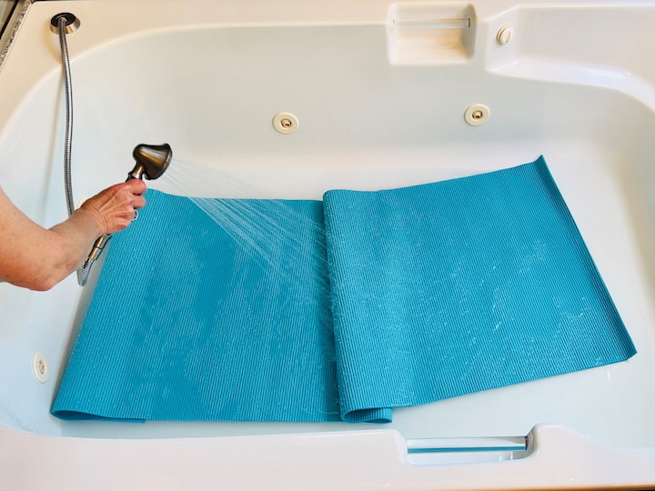 For a more thorough cleaning, give your Lululemon yoga mat or regular yoga mat a bath to remove dirt and grime. Add warm water to the bottom of your bathtub and mix it with some Castile soap. You won't see a lot of bubbles, and that is okay. Place your yoga mat into the bathtub, let it soak for 10 minutes, and wipe it with a sponge or damp cloth. Rinse it off when done, and use a towel to wipe it dry. Avoid hanging your yoga mat in direct sunlight, as UV rays can degrade it.