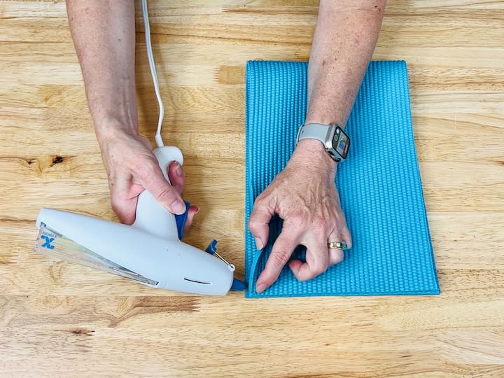 Turn your old yoga mat into a sleeve for your tablet or computer. Measure it against your device, make the necessary cuts, fold it in half, and hot glue the edges together.