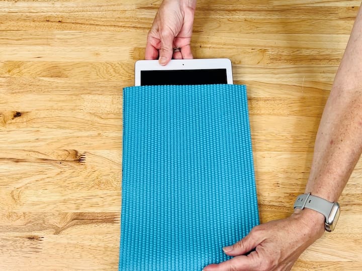 Turn your old yoga mat into a sleeve for your tablet or computer. Measure it against your device, make the necessary cuts, fold it in half, and hot glue the edges together.