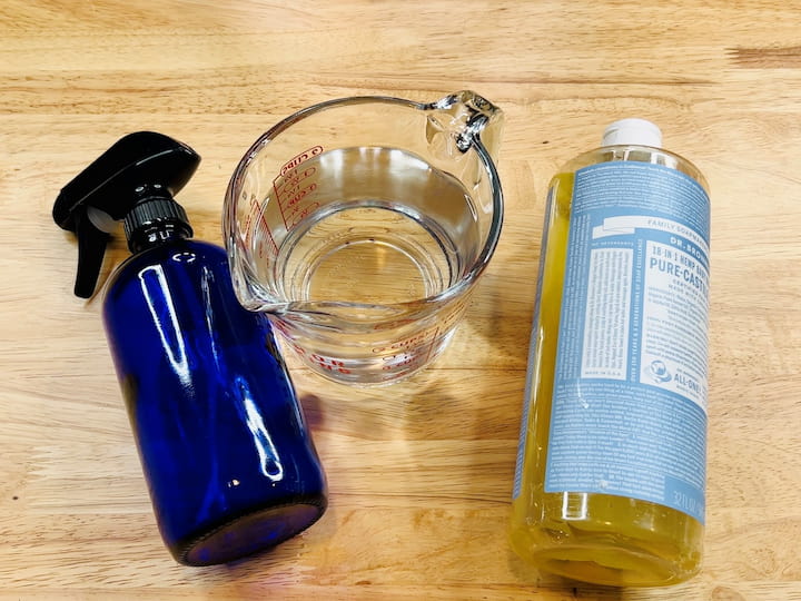 For our first cleaning spray, you'll only need a couple of ingredients. You'll need a cup of water and one tablespoon of pure Castile soap. Mix the water and Castile soap together in a measuring cup or bowl, then pour the mixture into a spray bottle.