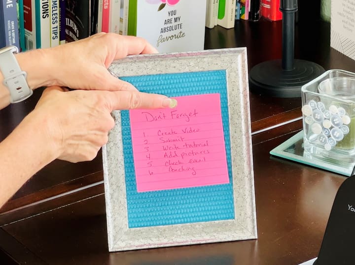 Transform a photo frame into a bulletin board by cutting a piece of the yoga mat to fit the back of the frame. Hot glue it in place and reassemble the frame.