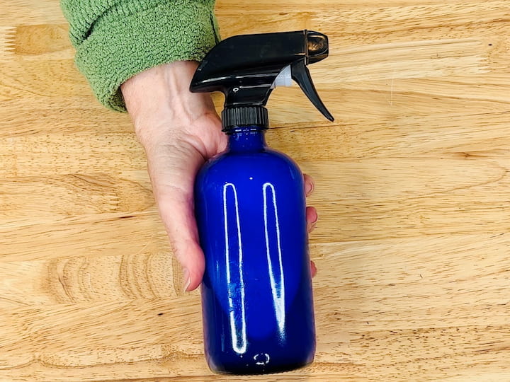 For our first cleaning spray, you'll only need a couple of ingredients.  You'll need a cup of water and one tablespoon of pure Castile soap. Mix the water and Castile soap together in a measuring cup or bowl, then pour the mixture into a spray bottle.
