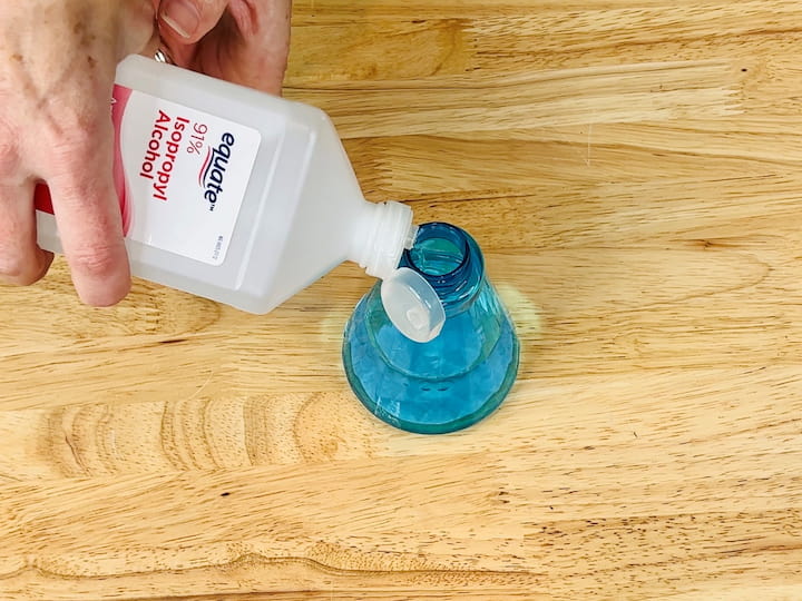 If you don't want to mix the cleaning solution, you can make a quick yoga mat cleaner by using rubbing alcohol. Look for a strong isotropic rubbing alcohol and pour it into a spray bottle. Spray it onto your yoga mat and then use a washcloth to wipe it off.