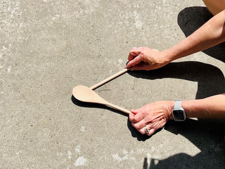 Start by hot gluing the handle of one wooden spoon to the back end of the spoon side of another wooden spoon.