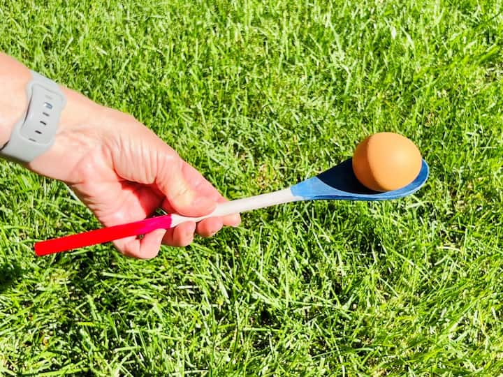 Use the wooden spoon as a tool for an egg game, where participants balance an egg on the spoon and carry it across the yard, passing it to others.