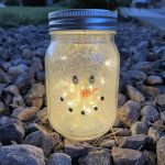 Create a frosty effect by swirling Pledge floor cleaner inside the jar, coating the entire surface. Add a touch of white glitter for a snowy sparkle. Once dry, draw a winter-themed face on the jar with Sharpie markers. Seal it with dishwasher safe Mod Podge or outdoor acrylic paint for durability.
